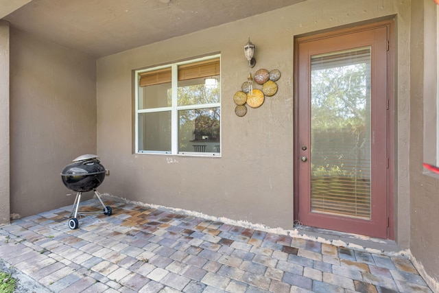 doorway to property with a patio area and stucco siding