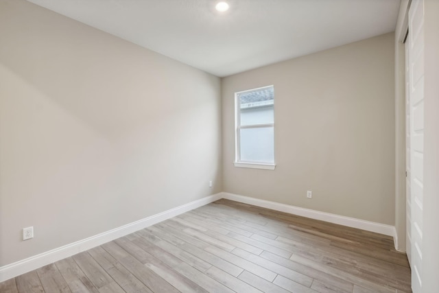 unfurnished room with baseboards and light wood-type flooring