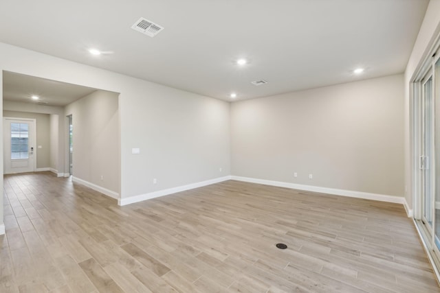 unfurnished room with visible vents, recessed lighting, light wood-type flooring, and baseboards