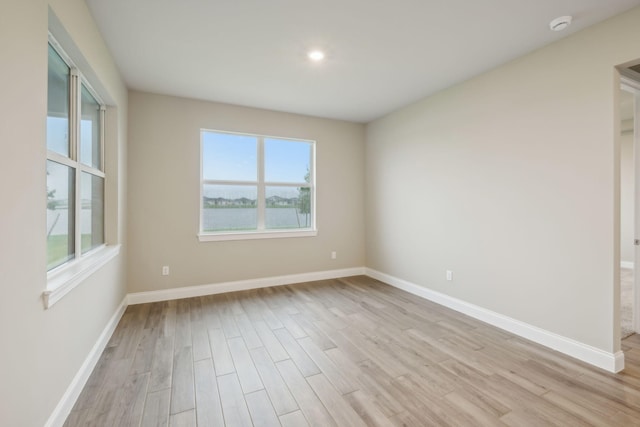 unfurnished room with baseboards and light wood-style floors
