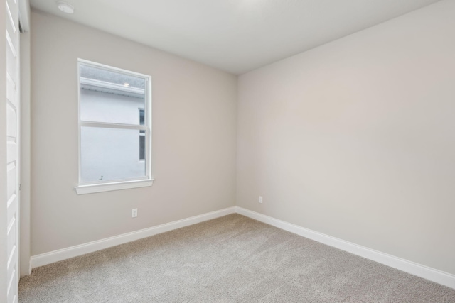 carpeted spare room with baseboards