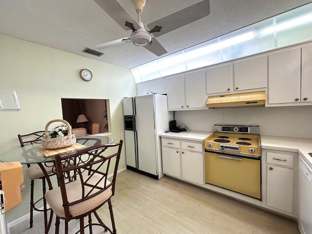 kitchen featuring under cabinet range hood, visible vents, light countertops, electric range oven, and white fridge with ice dispenser