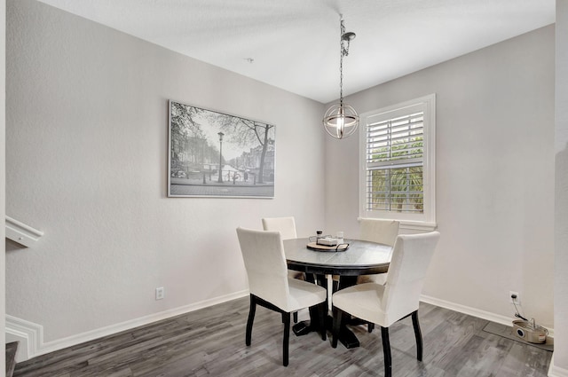 dining space featuring baseboards and wood finished floors