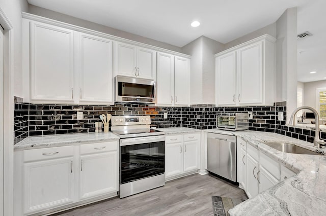 kitchen featuring white cabinetry, visible vents, appliances with stainless steel finishes, and a sink