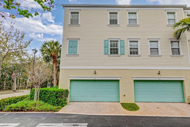 view of property exterior with a garage, driveway, and stucco siding