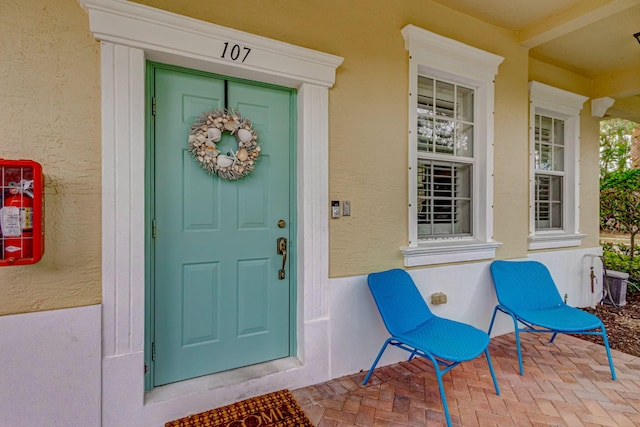 doorway to property featuring stucco siding