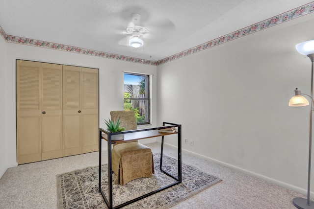 office area featuring a textured ceiling, carpet flooring, a ceiling fan, and baseboards