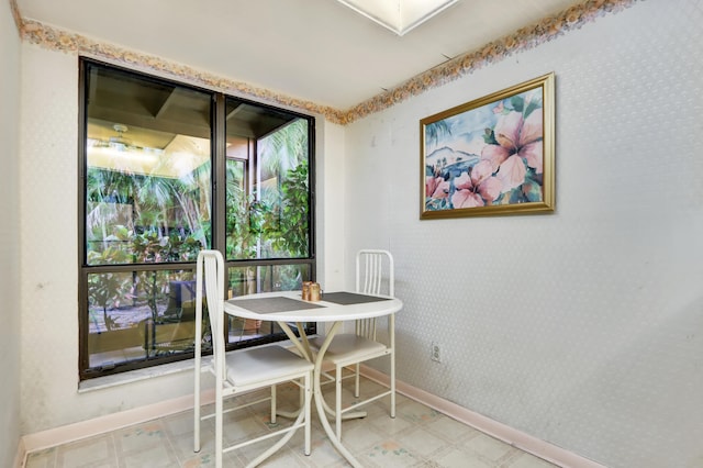 dining room with baseboards, tile patterned floors, and wallpapered walls