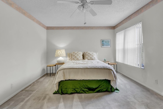 carpeted bedroom featuring a textured ceiling, a ceiling fan, and baseboards