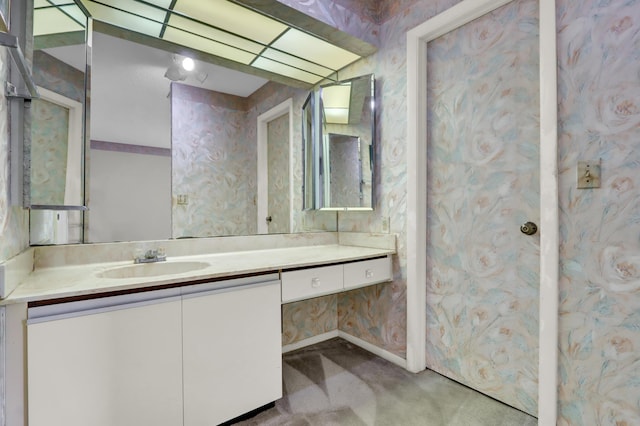 bathroom with wallpapered walls and vanity