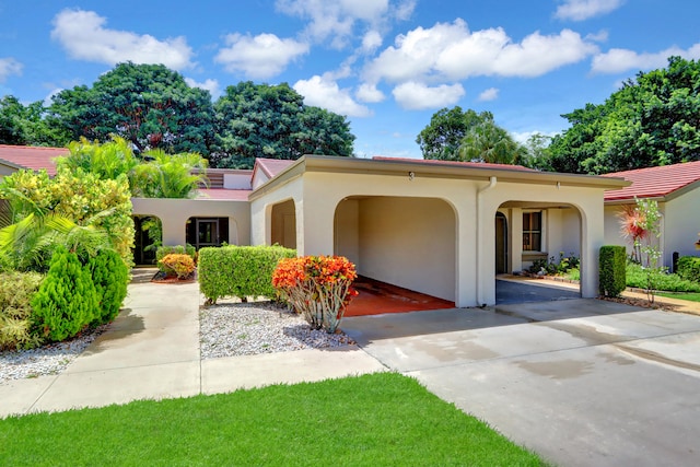 mediterranean / spanish house featuring concrete driveway and stucco siding