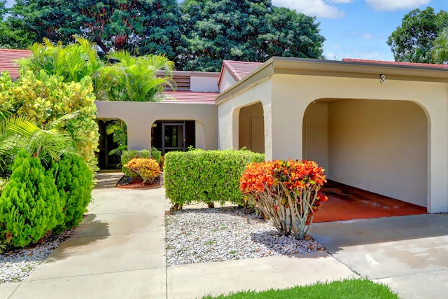 exterior space with a tile roof and stucco siding