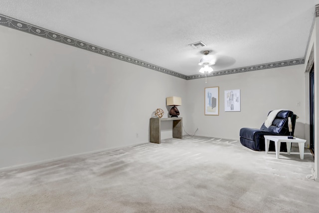 unfurnished room featuring carpet floors, a ceiling fan, visible vents, and a textured ceiling