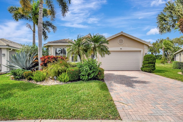 view of front of house featuring a tile roof, an attached garage, decorative driveway, a front lawn, and stucco siding