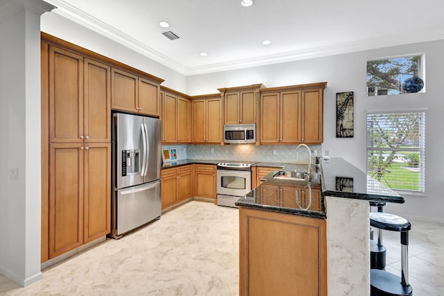 kitchen with stainless steel appliances, visible vents, a sink, a peninsula, and a kitchen bar