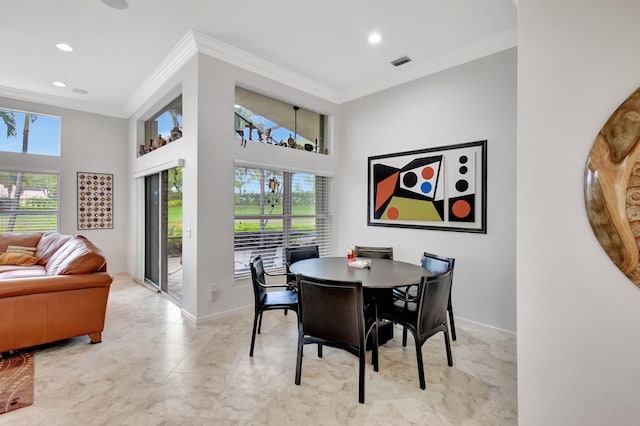 dining room with ornamental molding, a high ceiling, and visible vents