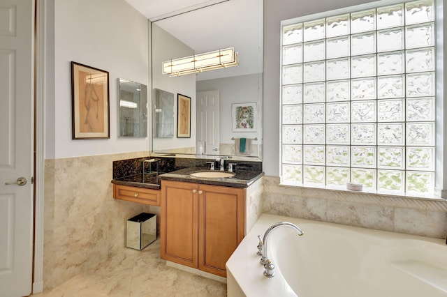 bathroom with tile walls, a bath, and vanity