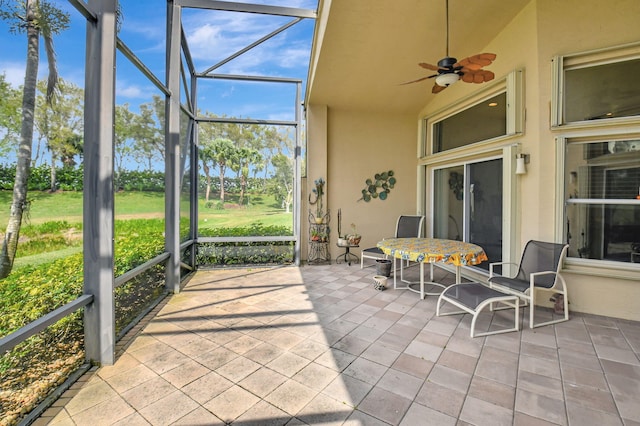 sunroom featuring lofted ceiling and a ceiling fan