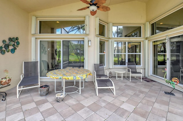 sunroom / solarium featuring lofted ceiling and ceiling fan