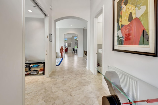 corridor featuring arched walkways and recessed lighting