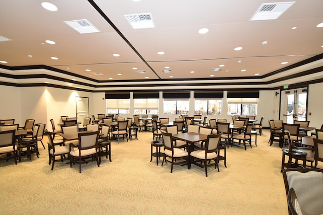 dining space with visible vents, a tray ceiling, and ornamental molding