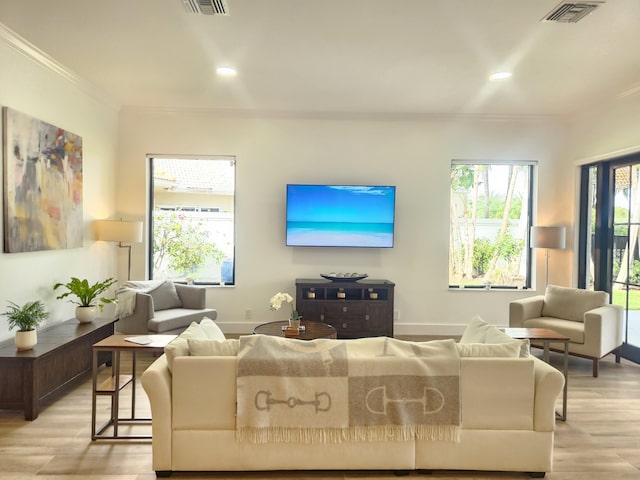 living area with recessed lighting, visible vents, baseboards, light wood-style floors, and ornamental molding