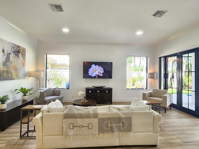 living area with ornamental molding, french doors, a wealth of natural light, and visible vents