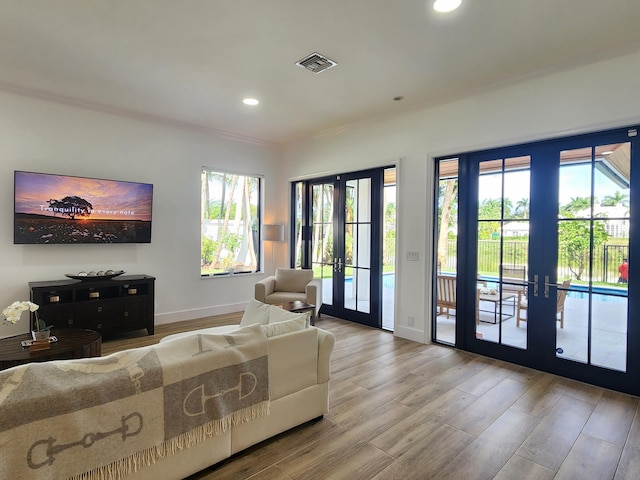 living area featuring baseboards, visible vents, wood finished floors, french doors, and recessed lighting