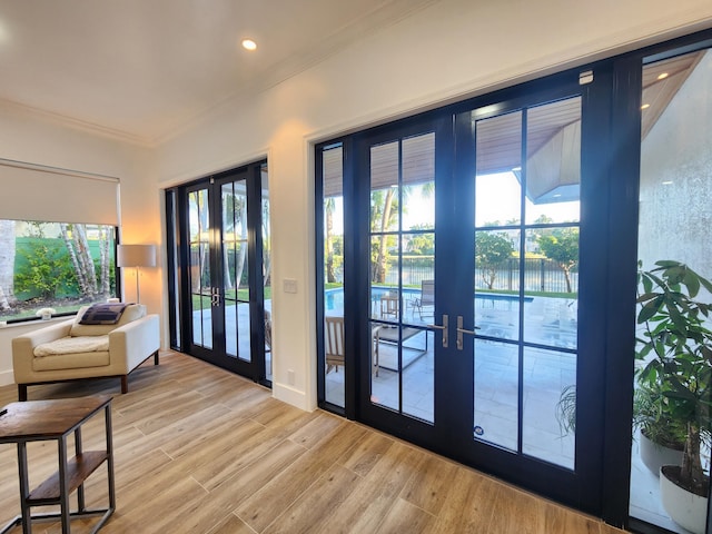 doorway with ornamental molding, recessed lighting, french doors, and light wood-style flooring