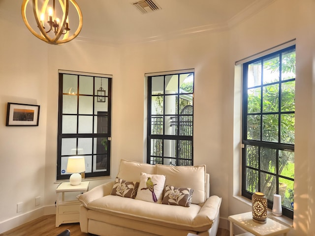 living area featuring plenty of natural light, visible vents, wood finished floors, and ornamental molding