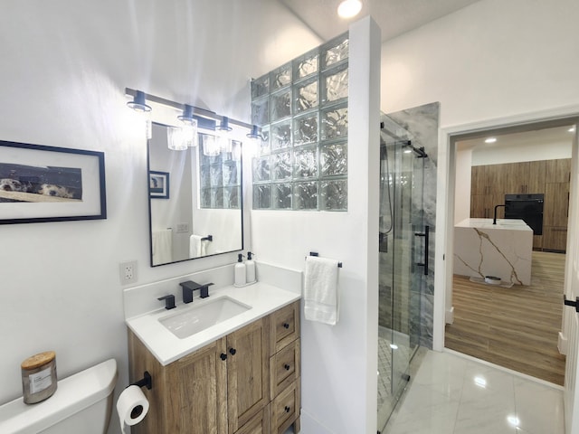 full bathroom featuring marble finish floor, a shower stall, toilet, and vanity