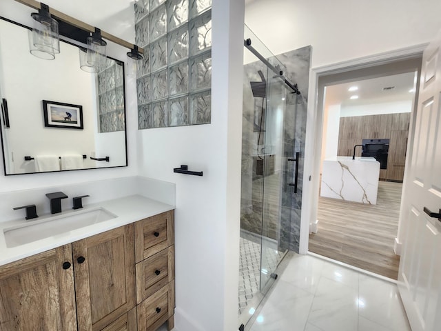 full bathroom with marble finish floor, a shower stall, and vanity