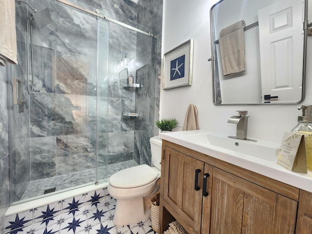 bathroom featuring toilet, a stall shower, and vanity