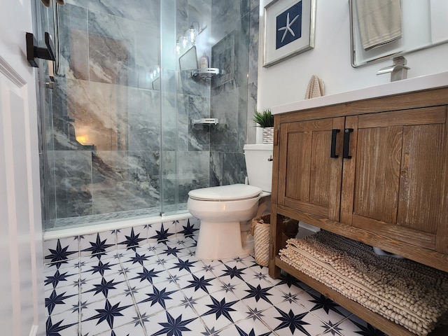 full bath with a stall shower, vanity, toilet, and tile patterned floors