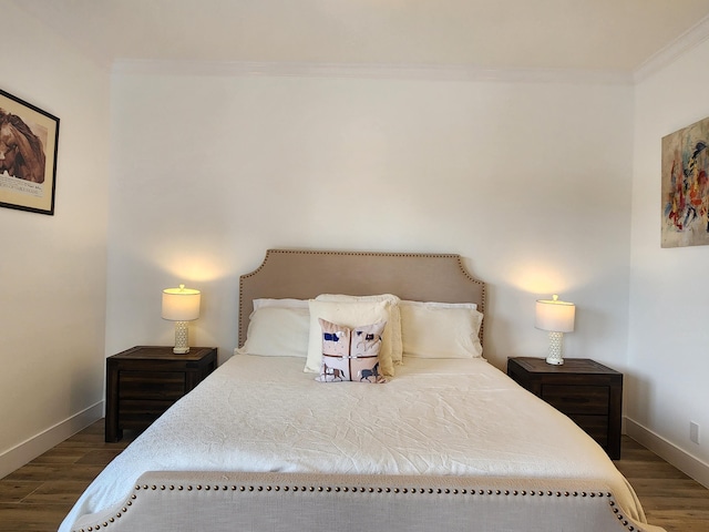 bedroom with baseboards, ornamental molding, and wood finished floors