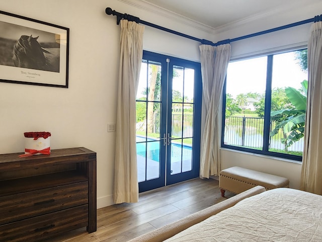 bedroom featuring ornamental molding, access to outside, french doors, and wood finished floors