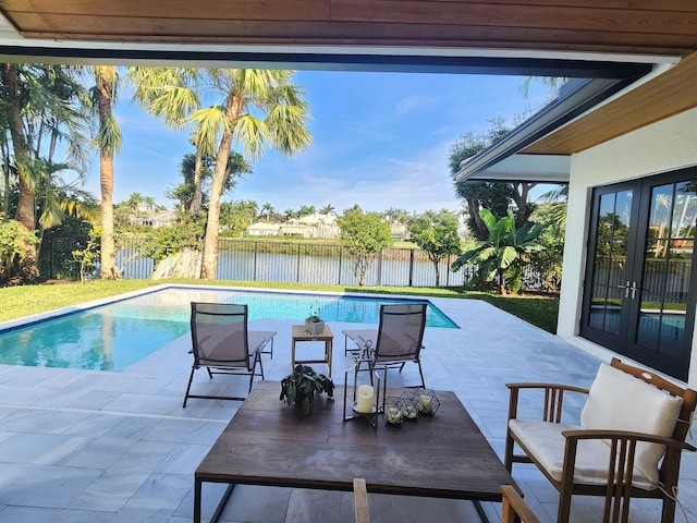 view of pool featuring a fenced in pool, french doors, a water view, a patio area, and a fenced backyard