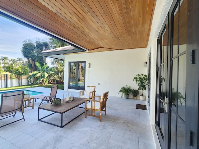 view of patio with french doors, fence, and a fenced in pool