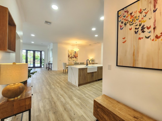 kitchen featuring visible vents, light countertops, light wood-type flooring, a sink, and recessed lighting