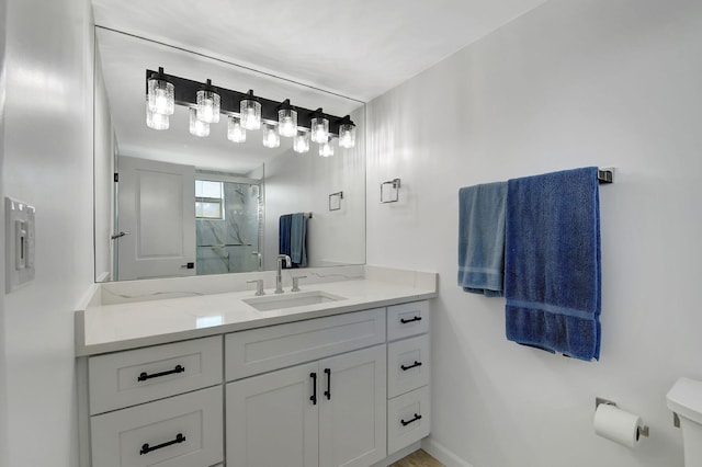 full bathroom featuring toilet, a marble finish shower, vanity, and baseboards