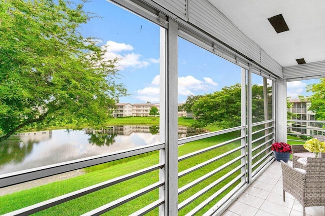 unfurnished sunroom featuring a water view