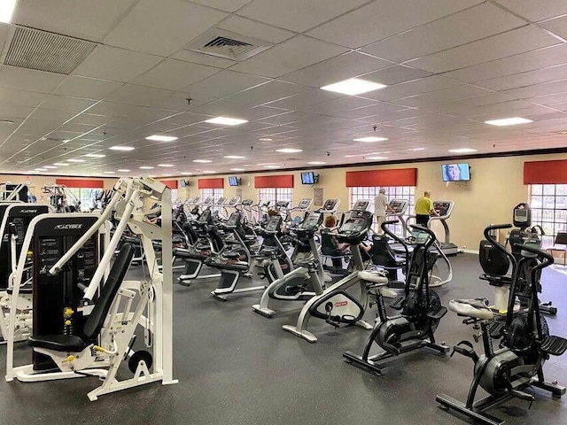 workout area with a paneled ceiling, baseboards, and visible vents