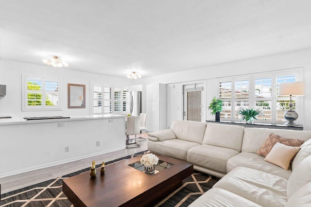 living area with baseboards and wood finished floors