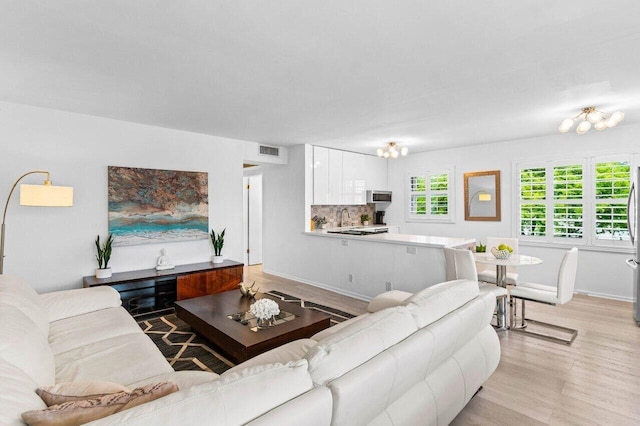 living room with light wood-style flooring and visible vents