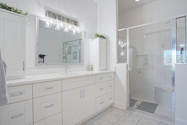 full bath featuring a stall shower, vanity, and tile patterned floors