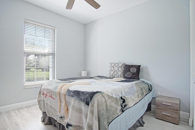 bedroom featuring ceiling fan, light wood finished floors, and baseboards