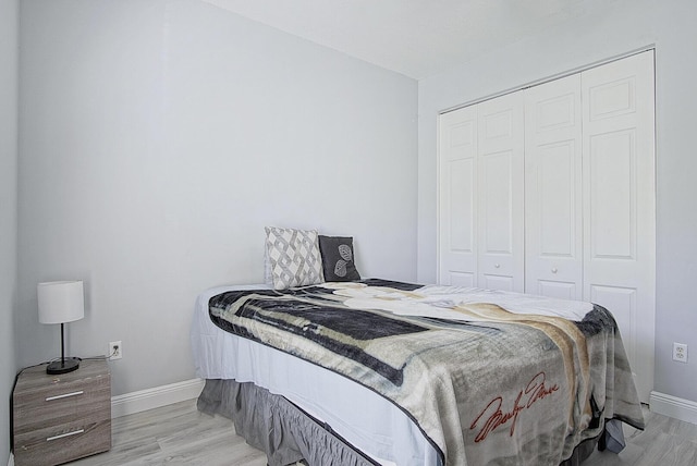 bedroom featuring a closet, baseboards, and wood finished floors