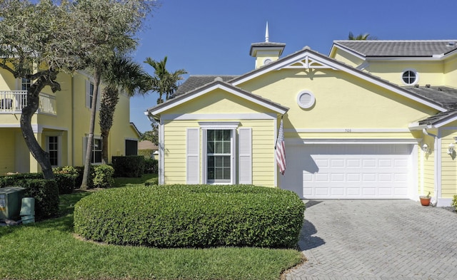 view of front of property with a garage, decorative driveway, and stucco siding