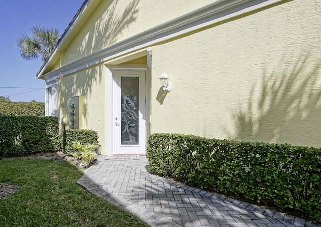 entrance to property featuring stucco siding