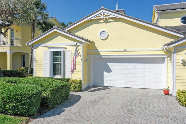 view of front of property featuring decorative driveway and stucco siding